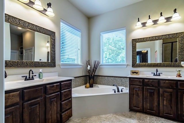 full bathroom featuring a garden tub, two vanities, a shower with door, and tile patterned floors