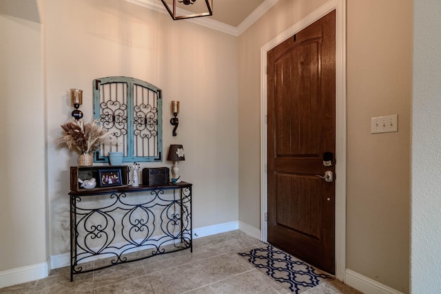 tiled foyer entrance with ornamental molding and baseboards