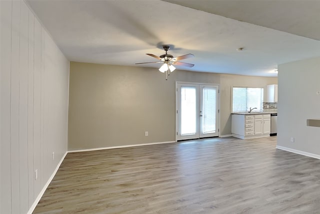 1625 Stockton Trl, Plano, TX 75023 - unfurnished living room featuring a ceiling fan, light wood-style floors, and baseboards