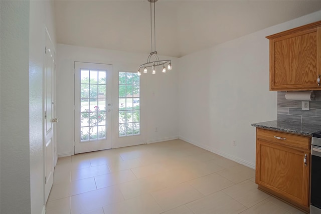 unfurnished dining area featuring baseboards and a chandelier
