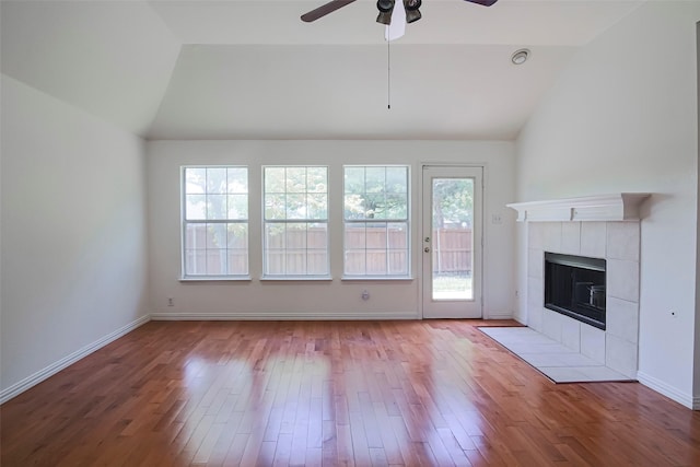 unfurnished living room featuring vaulted ceiling, wood finished floors, ceiling fan, a fireplace, and baseboards