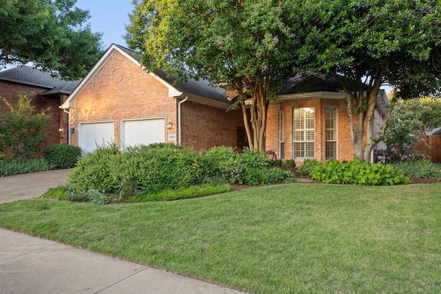 view of front of home with brick siding, a garage, a front lawn, and driveway