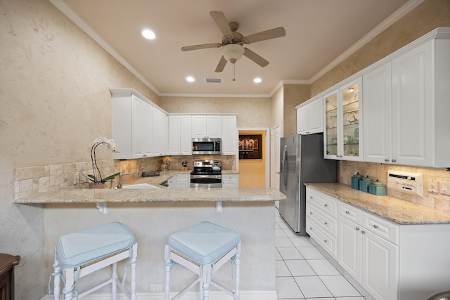 kitchen featuring stainless steel appliances, a peninsula, backsplash, ceiling fan, and recessed lighting