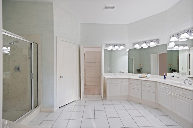 bathroom featuring tile patterned floors, a shower stall, and double vanity