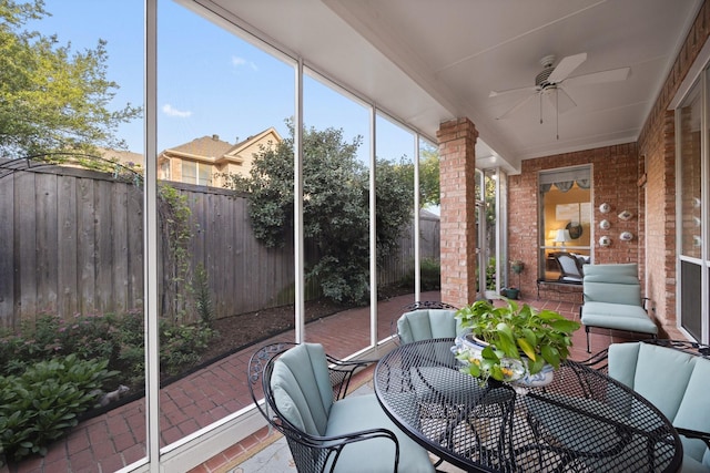 sunroom featuring ceiling fan and outdoor dining area
