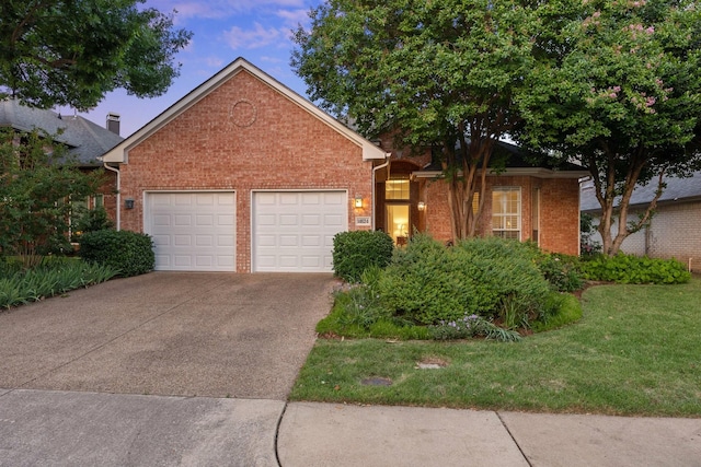 view of front of home featuring brick siding, a garage, concrete driveway, and a front lawn