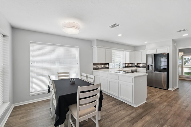 kitchen featuring stainless steel refrigerator with ice dispenser, white cabinetry, dark wood-style flooring, and recessed lighting