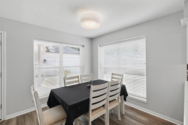 dining room with dark wood finished floors and baseboards