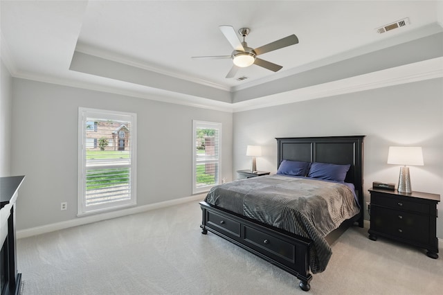 bedroom featuring a raised ceiling, light carpet, crown molding, baseboards, and ceiling fan