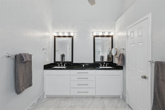 bathroom featuring double vanity and marble look tiles
