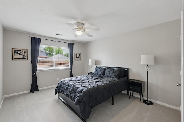 bedroom with light colored carpet, baseboards, and a ceiling fan