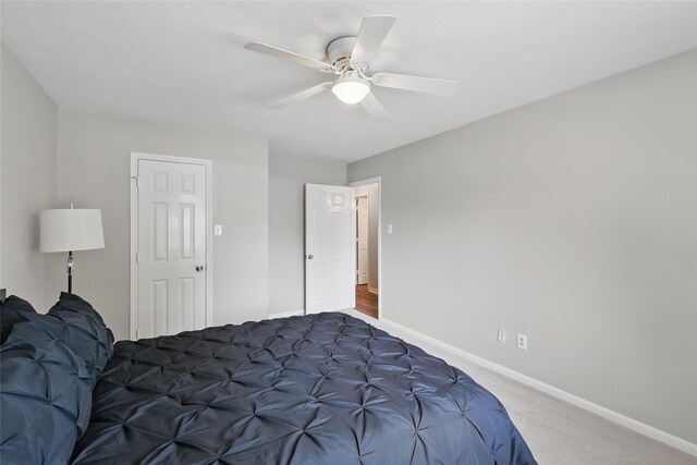 carpeted bedroom featuring baseboards and a ceiling fan