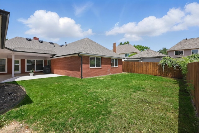 back of house with a patio, brick siding, and roof with shingles