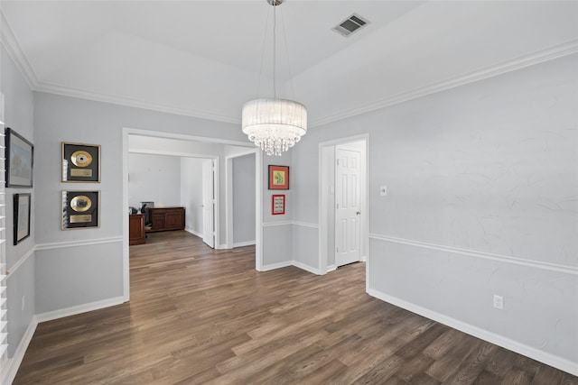 unfurnished dining area with ornamental molding, wood finished floors, a chandelier, and baseboards