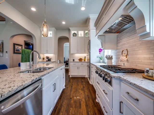 6209 Crystal Cove Ct, Mckinney, TX 75071 - kitchen featuring appliances with stainless steel finishes, a sink, arched walkways, custom exhaust hood, and white cabinetry