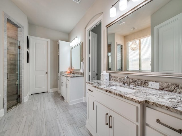 6209 Crystal Cove Ct, Mckinney, TX 75071 - bathroom featuring a stall shower, a chandelier, two vanities, and baseboards