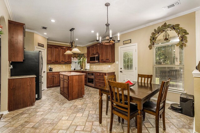1516 Cheyenne Trl, Mansfield, TX 76063 - kitchen featuring stainless steel appliances, a center island, backsplash, light countertops, and a chandelier