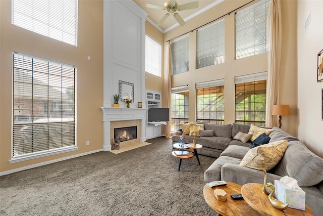 905 Sonora Dr, Allen, TX 75013 - carpeted living area featuring a towering ceiling, ceiling fan, a tile fireplace, baseboards, and ornamental molding