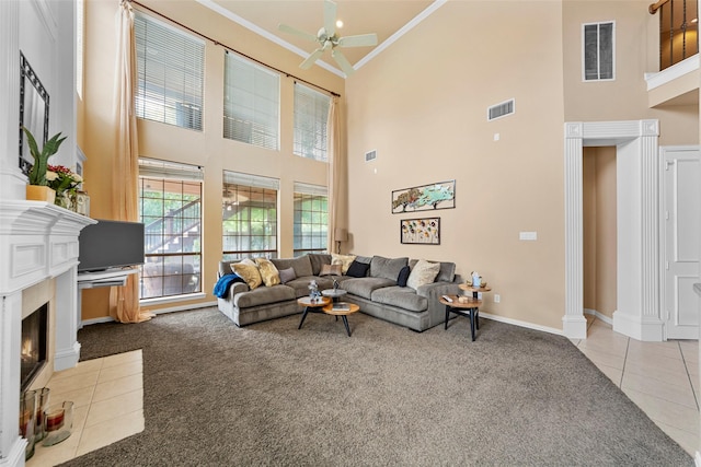 905 Sonora Dr, Allen, TX 75013 - carpeted living room with a towering ceiling, a ceiling fan, ornamental molding, tile patterned flooring, and a fireplace