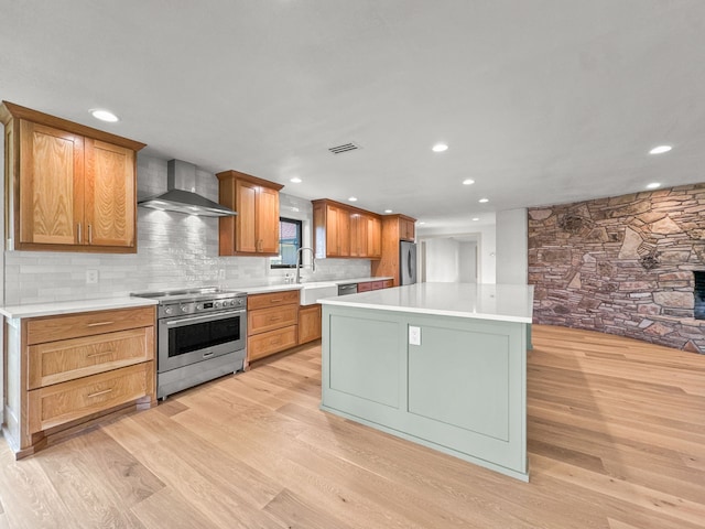 1551 Lower Tonk Valley Rd, Graham, TX 76450 - kitchen featuring stainless steel appliances, wall chimney exhaust hood, a sink, light wood-style flooring, and recessed lighting