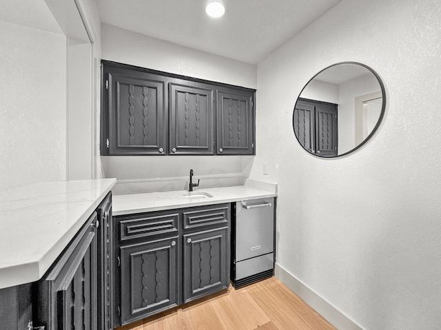 1551 Lower Tonk Valley Rd, Graham, TX 76450 - bar featuring dishwasher, light wood-style flooring, baseboards, and a sink