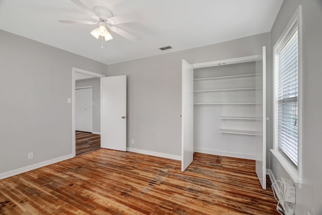 313 W 7th St, Irving, TX 75060 - unfurnished bedroom featuring wood finished floors, a closet, multiple windows, and baseboards