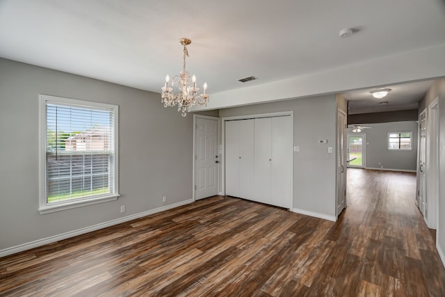 313 W 7th St, Irving, TX 75060 - unfurnished bedroom featuring dark wood-type flooring, a chandelier, baseboards, and a closet