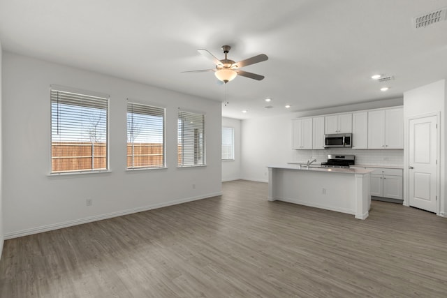 3008 Balmorhea Ln, Mckinney, TX 75071 - kitchen featuring stainless steel appliances, ceiling fan, open floor plan, light wood-style floors, and a sink