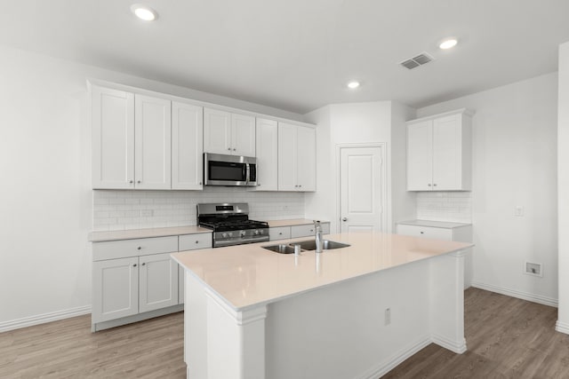 3008 Balmorhea Ln, Mckinney, TX 75071 - kitchen featuring stainless steel appliances, a sink, light wood-type flooring, baseboards, and a kitchen island with sink