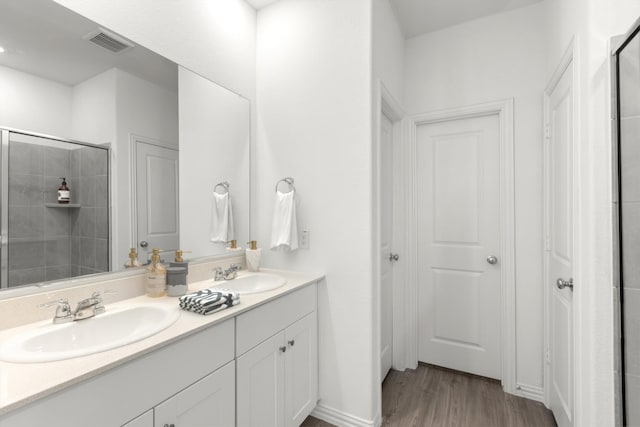 3008 Balmorhea Ln, Mckinney, TX 75071 - bathroom featuring double vanity, a stall shower, and wood finished floors