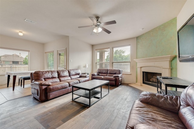 6712 Eliza Dr, Arlington, TX 76001 - living room with a ceiling fan, light wood finished floors, and a fireplace with raised hearth