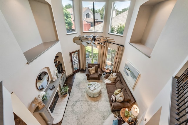 2466 Campfire Ln, Frisco, TX 75033 - living area featuring a high ceiling, a fireplace with raised hearth, plenty of natural light, and wood finished floors
