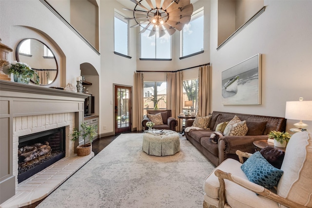 2466 Campfire Ln, Frisco, TX 75033 - living room with a brick fireplace, plenty of natural light, a towering ceiling, wood finished floors, and ceiling fan