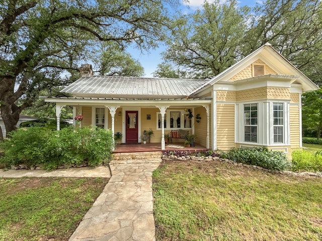 303 E Mclain, Iredell, TX 76649 - view of front of house with covered porch, metal roof, and a front lawn