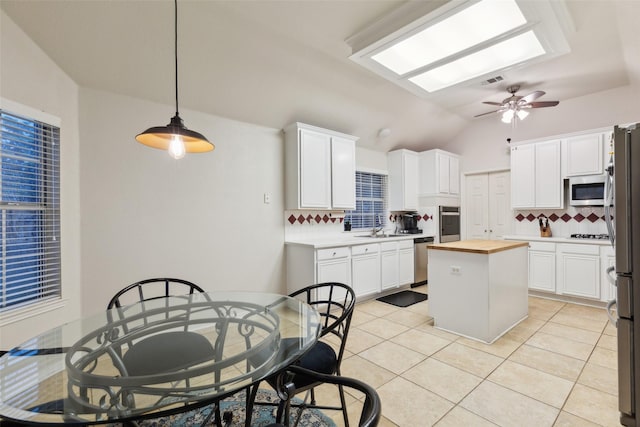 108 Rolling Rock Dr, Trophy Club, TX 76262 - kitchen featuring butcher block countertops, appliances with stainless steel finishes, tasteful backsplash, a sink, and lofted ceiling