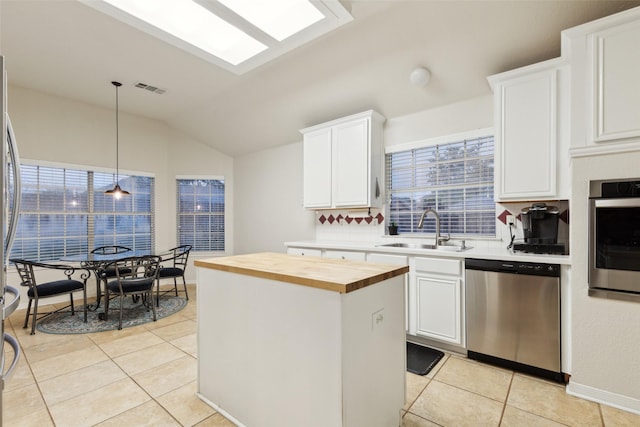 108 Rolling Rock Dr, Trophy Club, TX 76262 - kitchen with appliances with stainless steel finishes, a sink, wood counters, lofted ceiling, and a center island