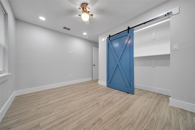 1213 Bowie St, Garland, TX 75040 - unfurnished bedroom featuring light wood-style floors, baseboards, a barn door, and recessed lighting