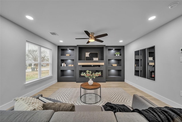 1213 Bowie St, Garland, TX 75040 - living room featuring baseboards, a ceiling fan, built in features, wood finished floors, and recessed lighting