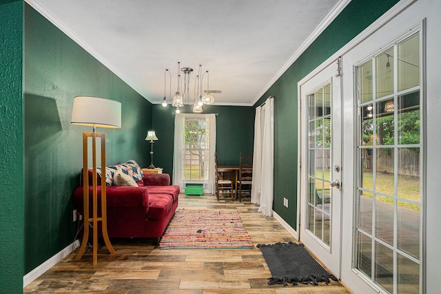704 Vaughn Dr, Burleson, TX 76028 - living area with crown molding, wood finished floors, french doors, a chandelier, and baseboards