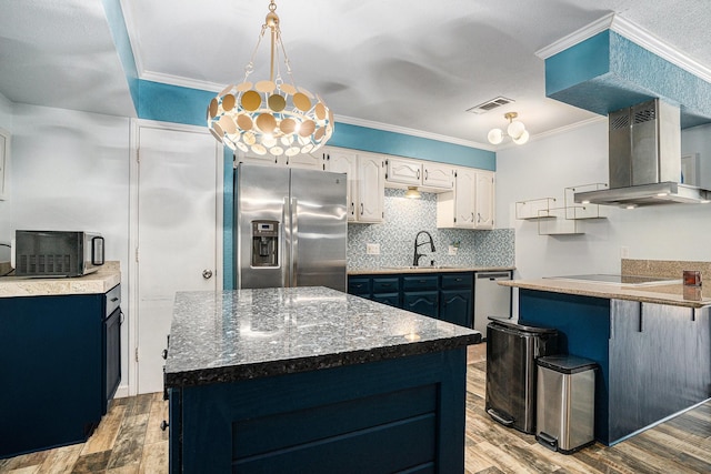704 Vaughn Dr, Burleson, TX 76028 - kitchen featuring appliances with stainless steel finishes, range hood, light wood finished floors, decorative backsplash, and crown molding