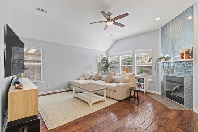 6436 Branchwood Trl, The Colony, TX 75056 - living room featuring a ceiling fan, wood-type flooring, baseboards, a tiled fireplace, and vaulted ceiling