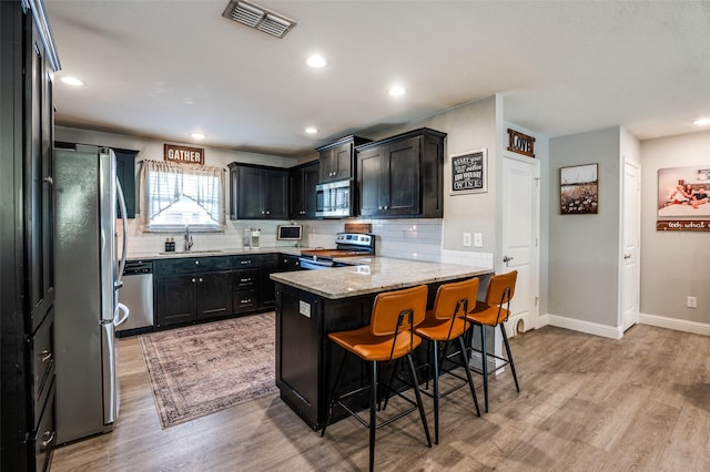211 Hilltop Cir, Blue Ridge, TX 75424 - kitchen with appliances with stainless steel finishes, a sink, light wood-style flooring, decorative backsplash, and recessed lighting