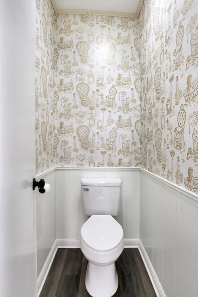 19413 US Highway 79 E, Jacksonville, TX 75766 - bathroom featuring wood finished floors, wallpapered walls, wainscoting, toilet, and ornamental molding