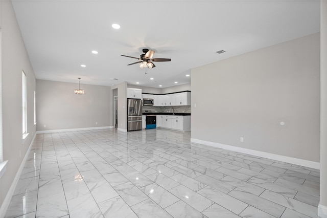 2636 Carter Ave, Fort Worth, TX 76103 - unfurnished living room with light marble finish flooring, a ceiling fan, baseboards, recessed lighting, and a chandelier
