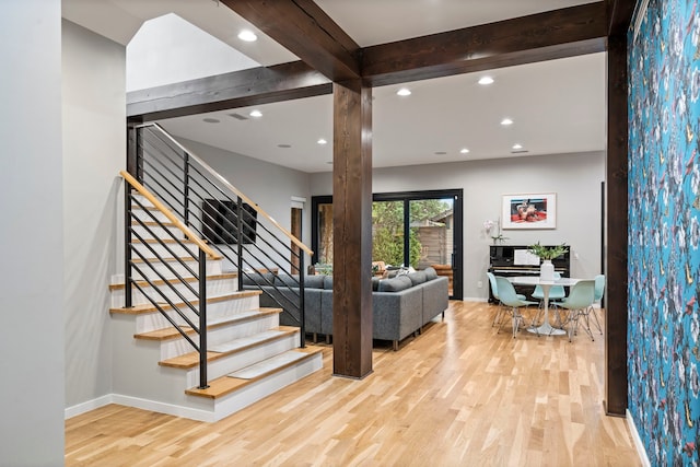 entryway with wood finished floors, baseboards, stairway, recessed lighting, and beam ceiling