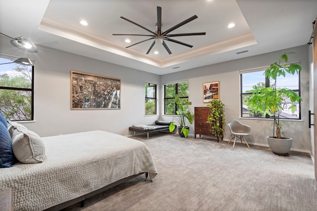 carpeted bedroom featuring a raised ceiling, recessed lighting, baseboards, and a ceiling fan