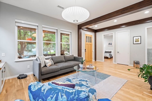 living room with plenty of natural light, light wood-style flooring, baseboards, beam ceiling, and recessed lighting