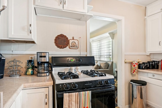 2509 Bird St, Fort Worth, TX 76111 - kitchen with range with gas stovetop, light countertops, white cabinetry, and tasteful backsplash