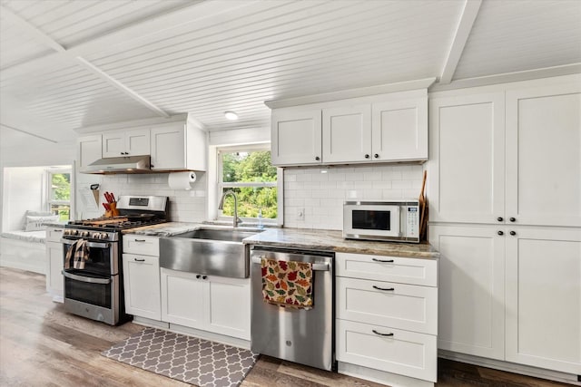 7928 Farm Rd Unit 127, Mount Pleasant, TX 75455 - kitchen with appliances with stainless steel finishes, a sink, tasteful backsplash, under cabinet range hood, and beamed ceiling