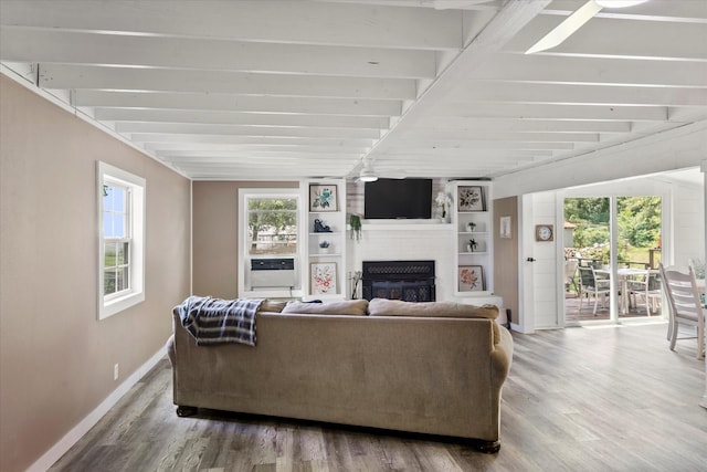 7928 Farm Rd Unit 127, Mount Pleasant, TX 75455 - living room with beam ceiling, a large fireplace, wood finished floors, and baseboards